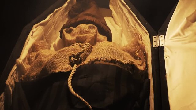 Halloween doll laying in coffin with strap around neck