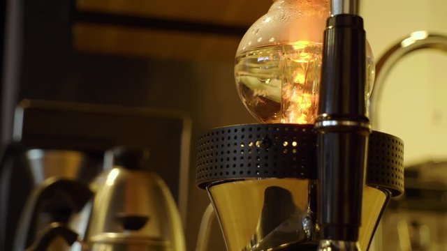 A coffee siphon boiling water to prepare for pouring over grounded coffee.