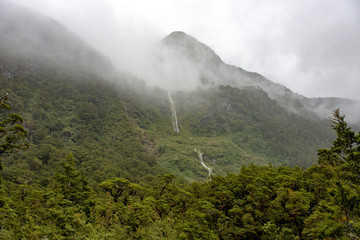 Mist clinging to mountainside with waterfall