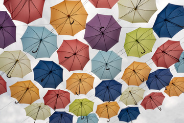 Different colors of umbrellas view from below. Colorful umbrellas on clear sky background