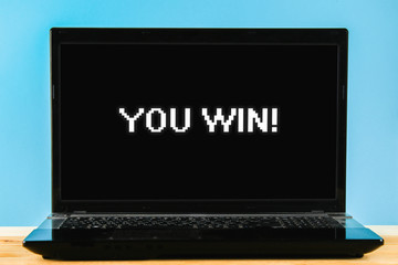Winning a computer game. Laptop on the table.