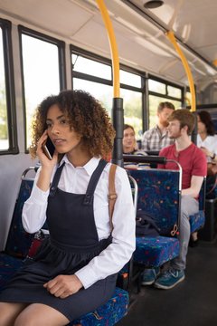 Female commuter talking on mobile phone while travelling in