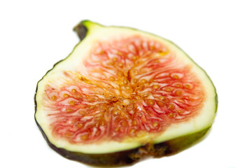Close-up of a ripe fig fruit slice on white background.