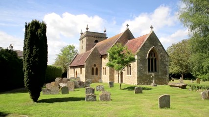Old church and graves in English village churchyard