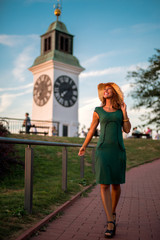 Fototapeta premium Beautiful young woman walking towards the sunset while smiling