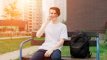 Student smiles and speaks on the phone. Street style