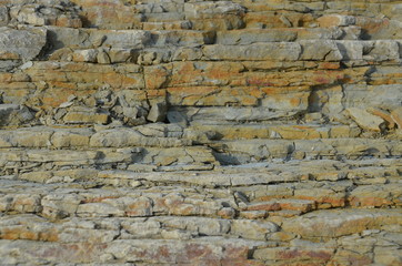 Natural rock structure background or texture. Lined rock with different natural colors.
