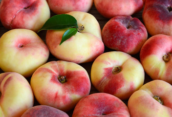 Chinese flat donut peaches also known as  Saturn donut, Doughnut peach,Paraguayo as a background.Healthy eating or diet concept.Selective focus.