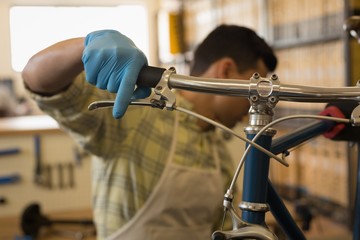 Man examining bicycle brake in workshop