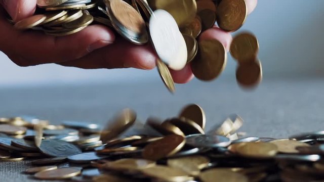 Businessman holding coins in his palms. Slow motion