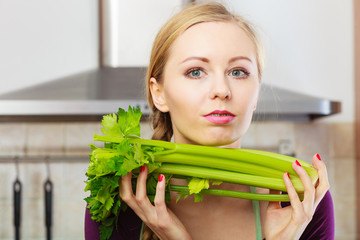 Naklejka premium Woman in kitchen holds green celery