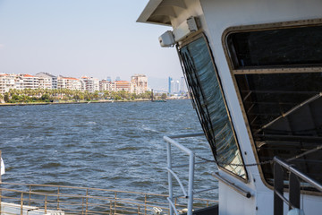 Top view of vehicle and passenger ferry travelling between Uckuyular and Bostanli ferry terminals across Izmir bay.