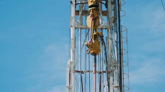 Top Drive System (TDS) Spinning for Oil Drilling Rig at blue sky - Oil and Gas Industry.
