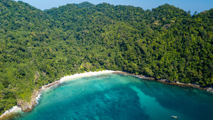 A beautiful, deserted tropical beach surrounded by lush green jungle and tropical coral reef (Mergui Archipelago, Myanmar)