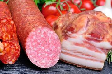 Sausage with cherry tomatoes and garlic on rustic table