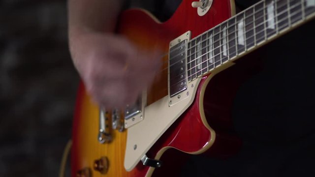 Loosely strumming chords on a Les Paul style guitar