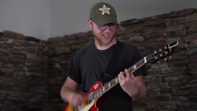 Man rocking out while playing his Les Paul style guitar