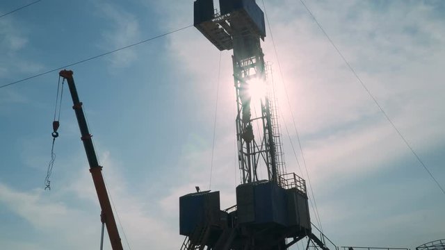 Top Drive System (TDS) Spinning for Oil Drilling Rig at sunset sky - Oilfield Industry