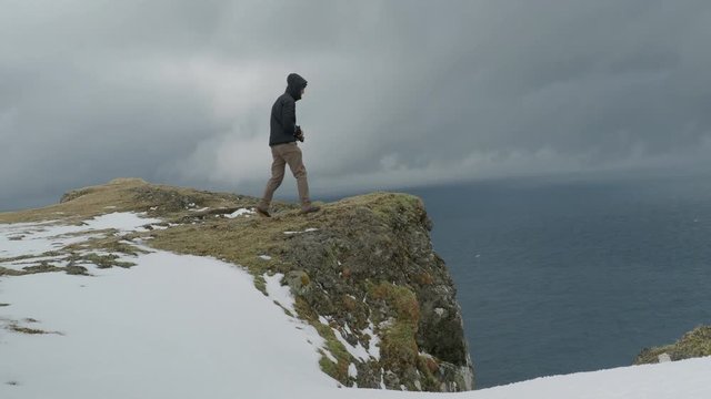 Adventure photographer taking dramatic photo in the Faroe Islands