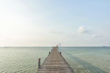 Fototapeta premium Long wooden bridge go to pavilion on the sea in beautiful tropical island, Thailand.