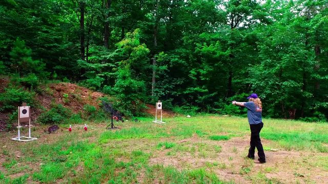 Woman practicing at outdoor pistol target range
