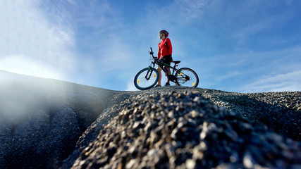 Naklejka na ściany i meble Mountain Bike cyclist on top of a mountain .