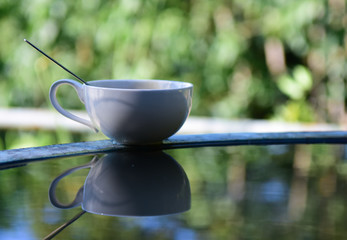 Coffee cup Reflection on water background.