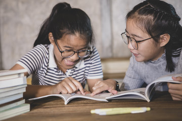 two asian student reading a school book with happiness emotion