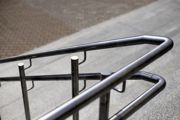Stainless steel round, comfortable railing, marble gray steps. A flight of stairs, the entrance to a large building.