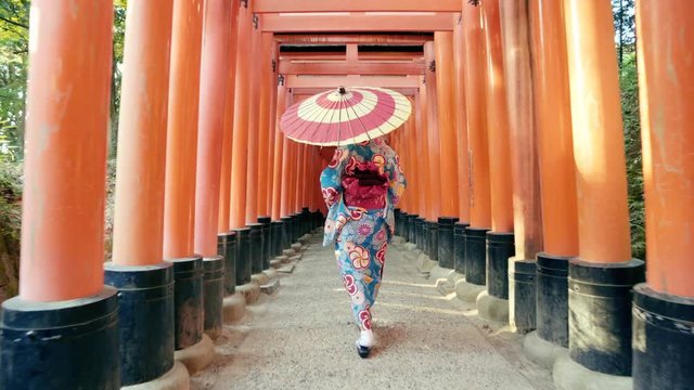 Asian women in traditional japanese kimonos walking at Fushimi Inari Shrine in Kyoto, Japan. 4K