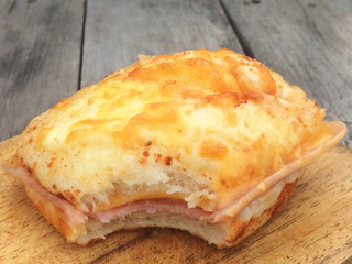 Closeup homemade hamburger with bite marks on wooden table.
