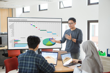 Project management dashboard concept. Man presenting to colleagues at a meeting about project management. - 218301309
