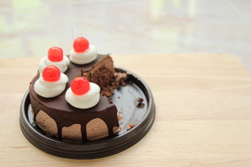 Chocolate cake cut into several pieces on brown background,top view with copy space.