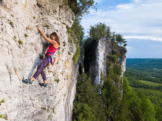 Fototapeta premium A beautiful woman rock climbing in Ontario, Canada.
