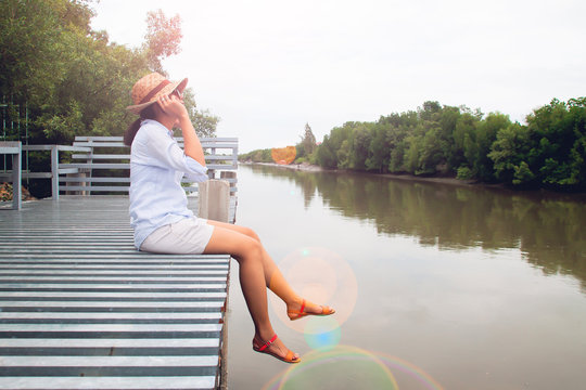 Happy woman in straw hat and casual style clothing enjoying beautiful location