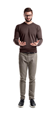 A Young Bearded Man In Cargo Pants Looks Down On His Both Hands Cupped As If Holding Something.