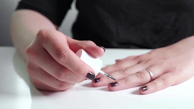 Woman paints her fingernails black