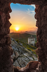 Obraz premium Rocca Calascio (Italy) - The ruins of an old medieval village with castle and church, over 1400 meters above sea level on the Apennine mountains in the heart of Abruzzo, at sunset.