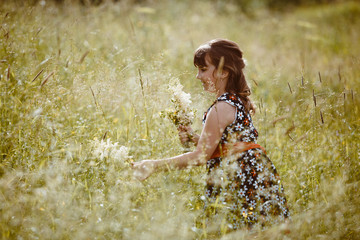 girl walking on the field next to the wildflowers