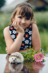 girl and hedgehog summer at the table
