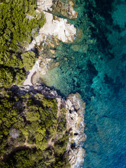 Aerial view of an amazing rocky and green coast bathed by a transparent and turquoise sea. Sardinia, Italy.