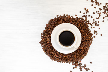 Coffee cup and coffee beans on wooden table