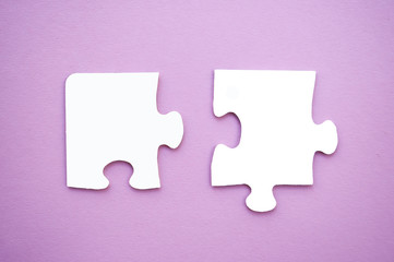 Puzzle pieces on pink background. Autism awareness day.