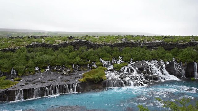 Colorful blue aqua turquoise color water waterfall azure cascades Hraunfossar Lava Falls in Iceland, landscape view