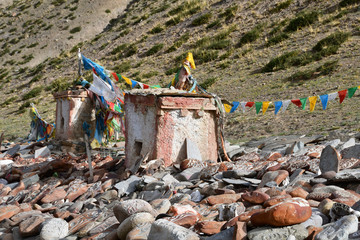 Tibet. Ancient stupa and buddhist prayer stones with mantras and ritual drawings on the trail from...
