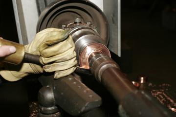 Worker  working  with hand on turn in a copper factory.