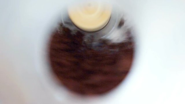 Macro closeup flat top view down of raw vegan chocolate dessert brownie dates nut mix in food processor with sound of blades churning, mixing food