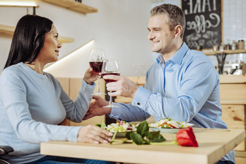 Good mood. Wonderful lovely couple spending time in a restaurant while discussing daily issues
