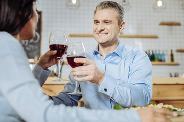 Falling in love. Handsome attractive man looking at a woman while drinking wine