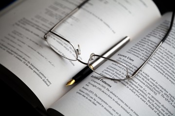 Glasses And Fountain Pen On Open Book Close-up